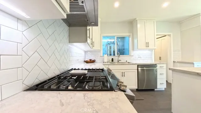 a kitchen with a stove a sink and a refrigerator