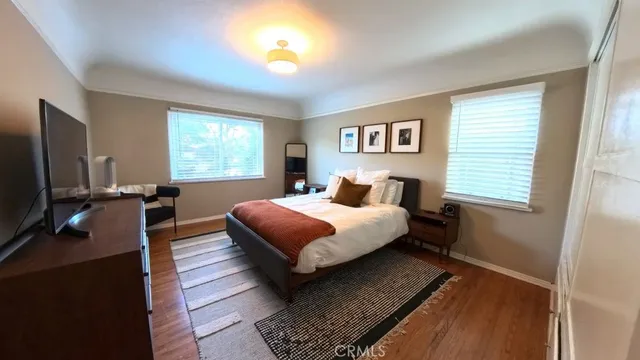 a bedroom with a bed and a dresser next to a window
