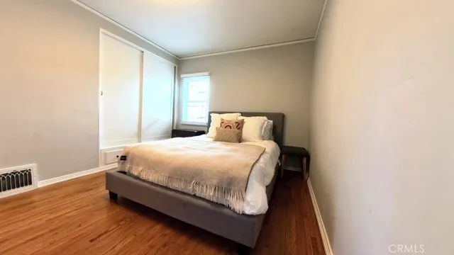 a bedroom with a bed and wooden floor
