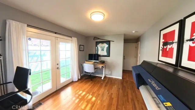 a living room with a bed furniture and a flat tv screen next to a window