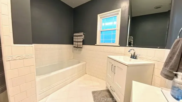 a bathroom with a tub sink and mirror