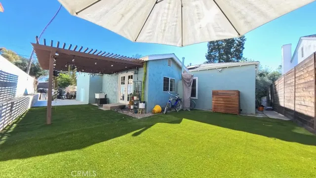 a view of a house with backyard and sitting area