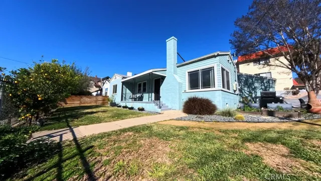 a view of a house with backyard and a tree