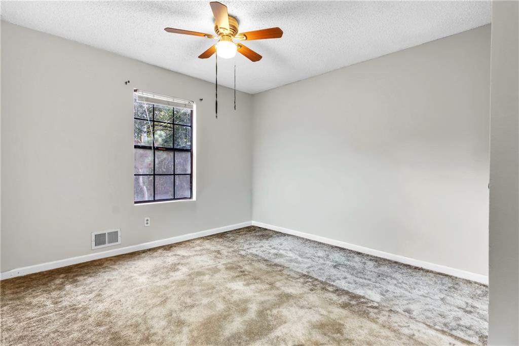 393 Cedar Trace Southwest Marietta, GA 30008 - Photo 15 of 33 an empty room with windows and chandelier fan