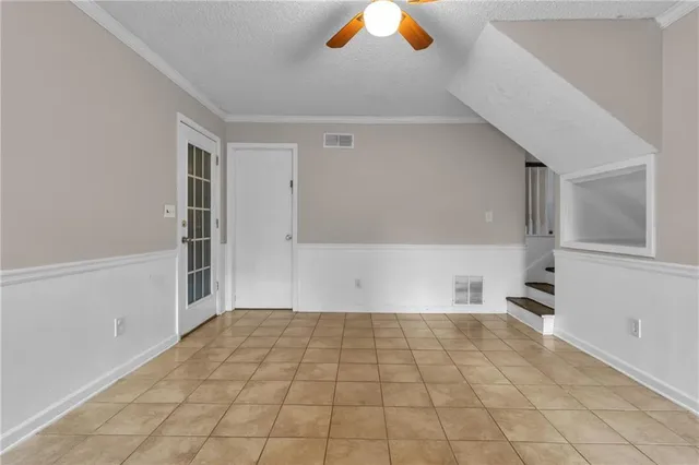 a view of an empty room with white walls and a window