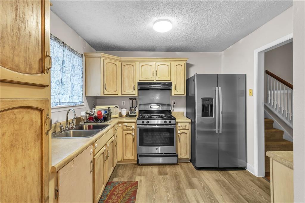393 Cedar Trace Southwest Marietta, GA 30008 - Photo 8 of 33 a kitchen with stainless steel appliances granite countertop a refrigerator a sink dishwasher a stove and a dining table with wooden floor