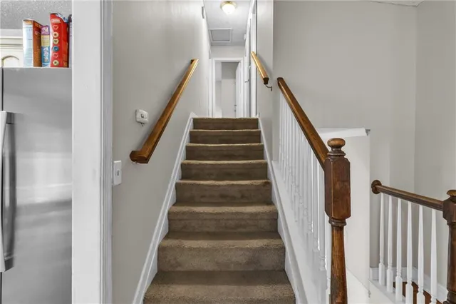 a view of staircase with lots of frames on wall and wooden floor