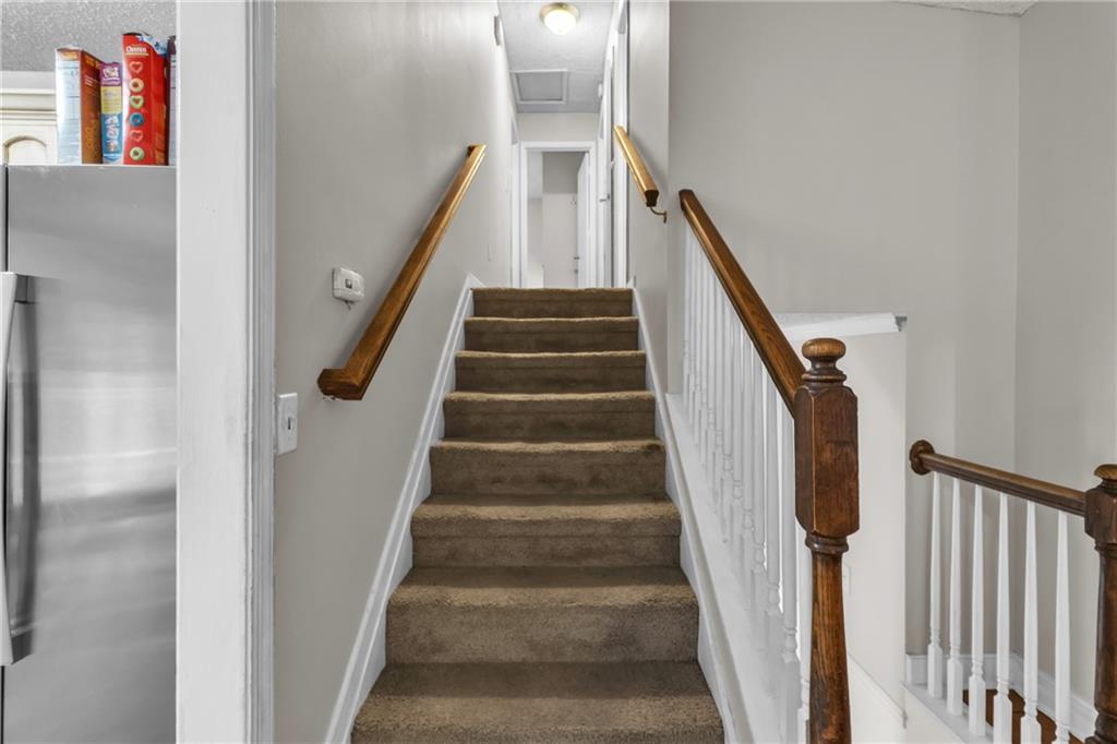 393 Cedar Trace Southwest Marietta, GA 30008 - Photo 10 of 33 a view of staircase with lots of frames on wall and wooden floor