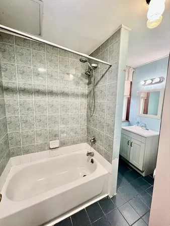 a bathroom with a bathtub a sink and a mirror