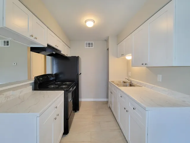 a kitchen with granite countertop a sink and a stove