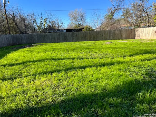 a view of a backyard with potted plants and wooden fence