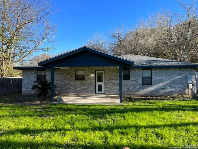 a view of a house with a yard patio and fire pit