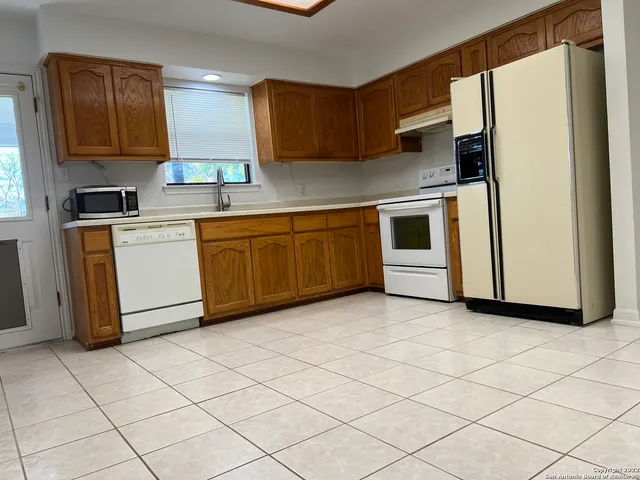 a kitchen with stainless steel appliances granite countertop a refrigerator sink and cabinets