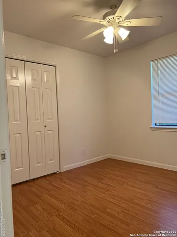 a view of a room with wooden floor and a ceiling fan