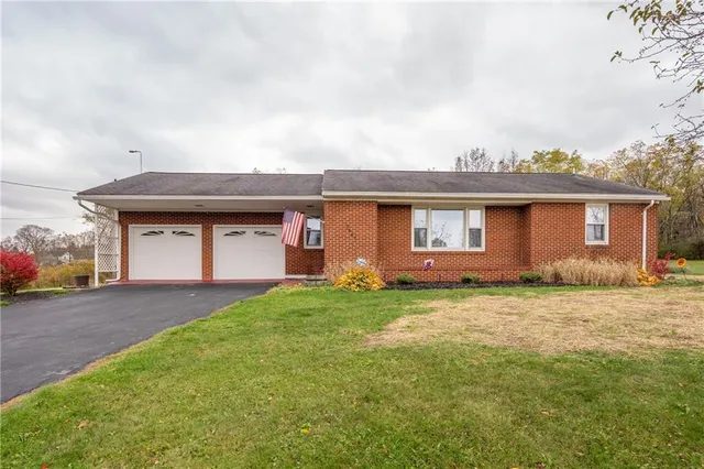 a view of a yard in front of a house with large trees