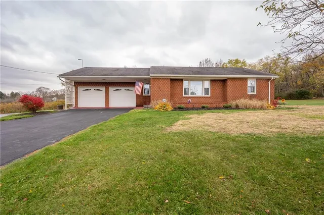 a view of a house with a yard and garage