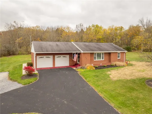a aerial view of a house next to a big yard and large trees