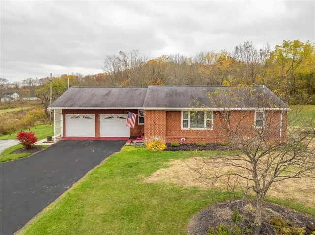 a view of a house with a yard and garage