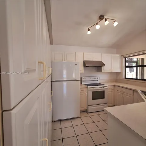 a kitchen with white cabinets and white appliances