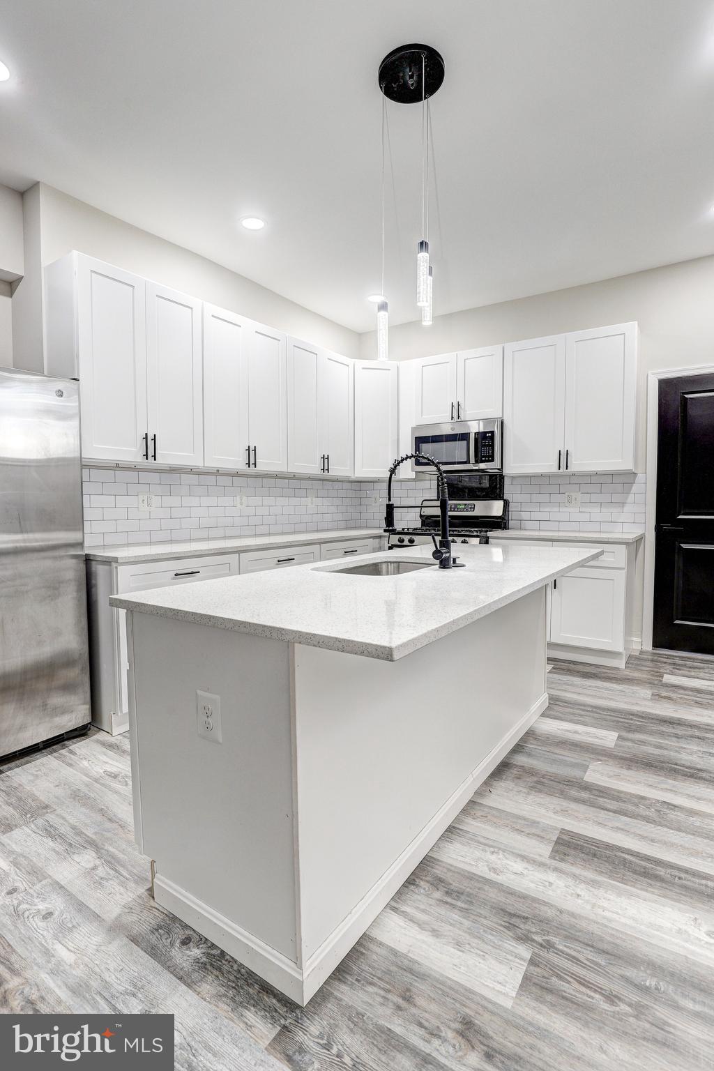 428 South Augusta Avenue Baltimore, MD 21229 - Photo 12 of 28 a kitchen with kitchen island a stove a sink and a refrigerator