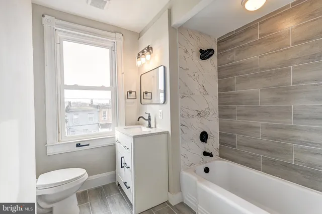 a bathroom with a bathtub toilet and window
