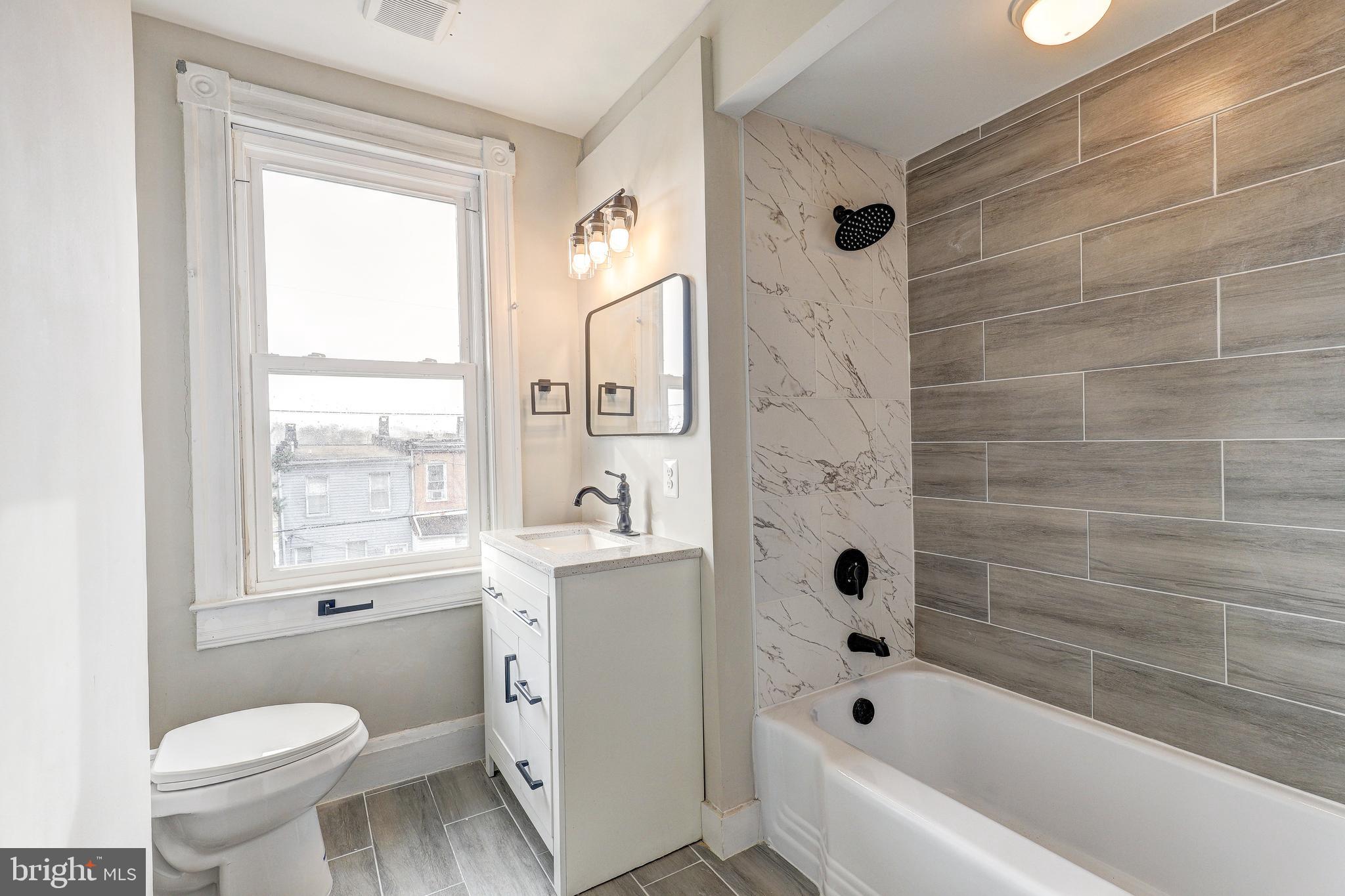 428 South Augusta Avenue Baltimore, MD 21229 - Photo 16 of 28 a bathroom with a bathtub toilet and window
