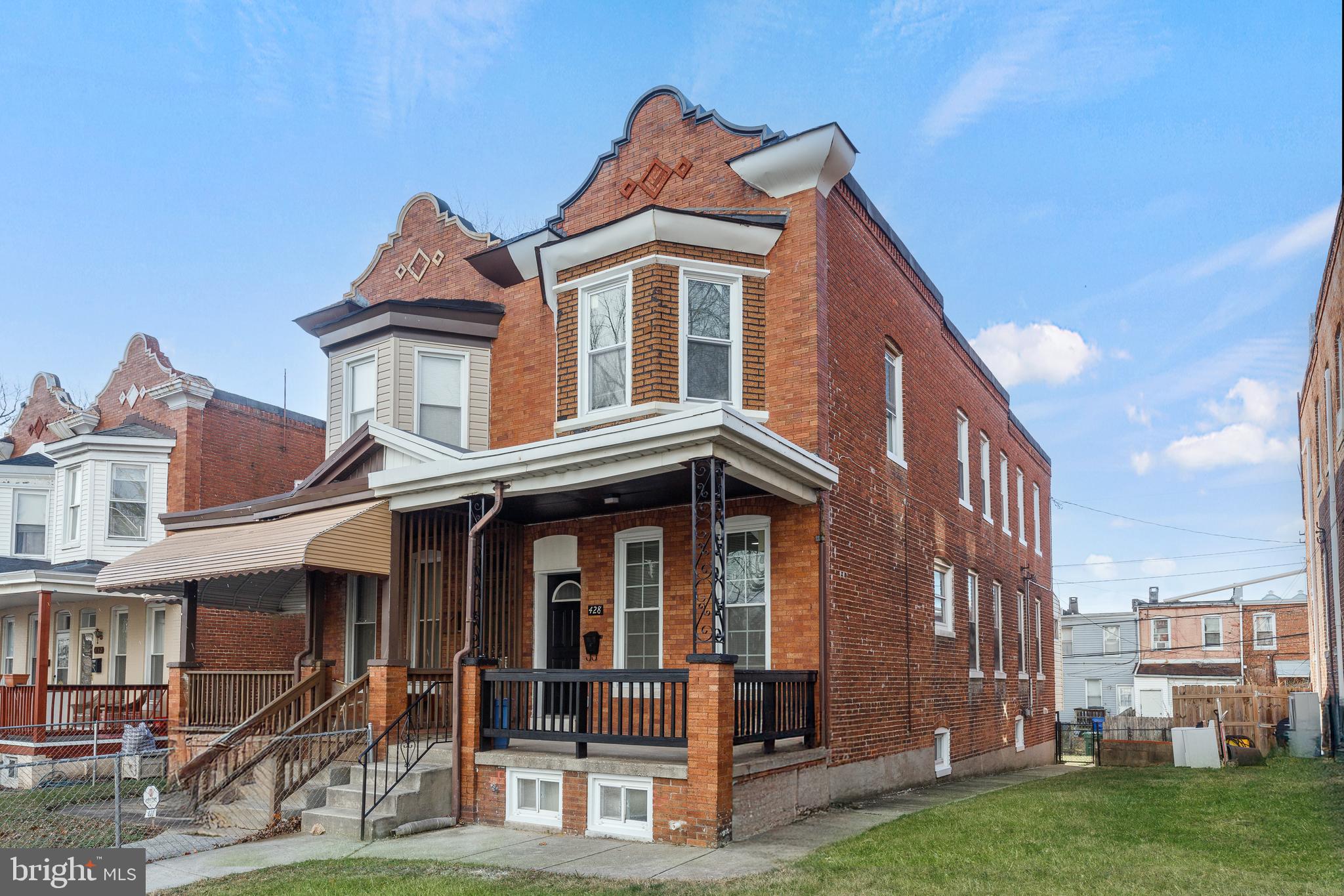 428 South Augusta Avenue Baltimore, MD 21229 - Photo 2 of 28 a view of a white house with large windows next to a yard