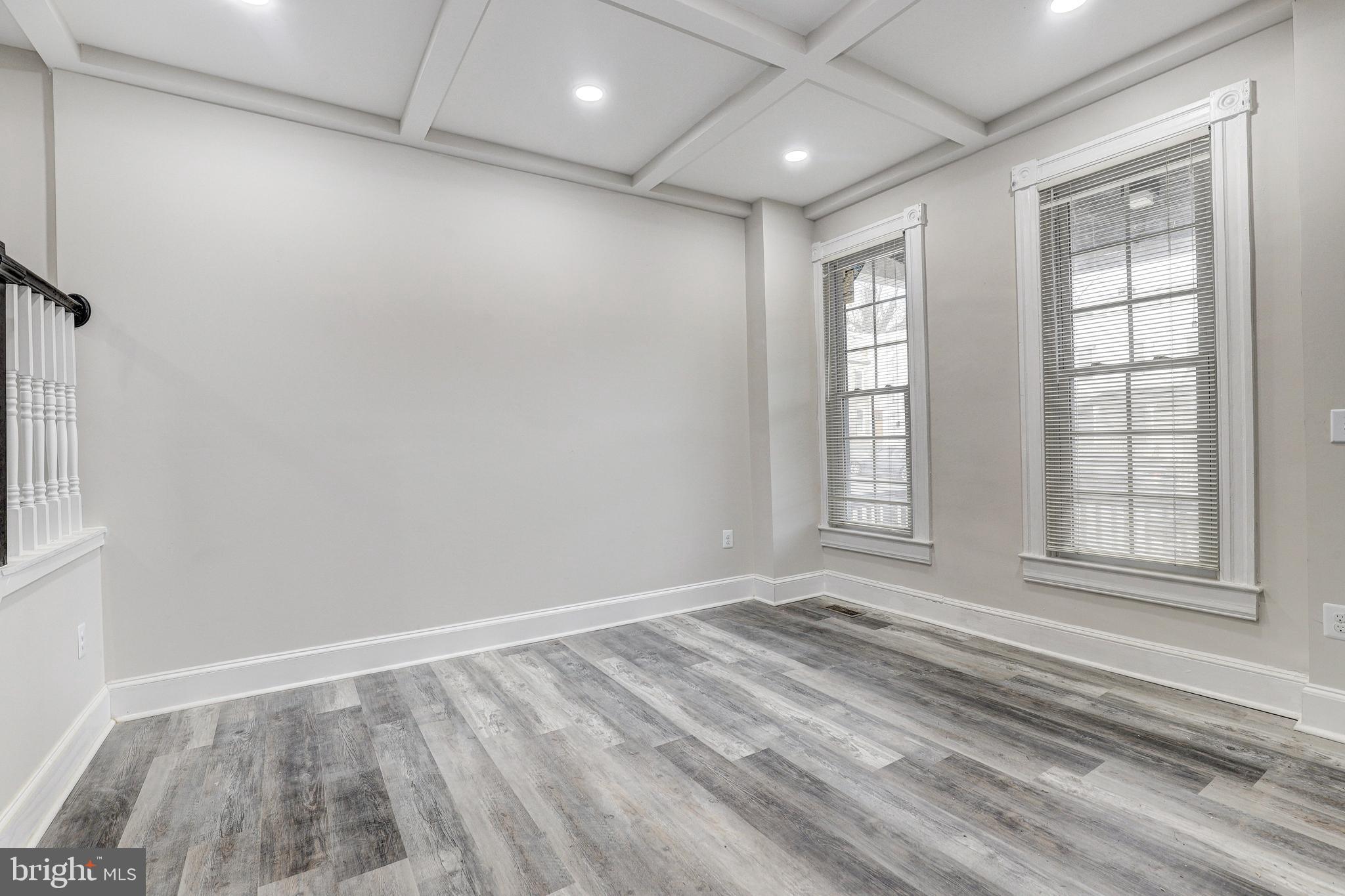 428 South Augusta Avenue Baltimore, MD 21229 - Photo 6 of 28 an empty room with wooden floor and windows