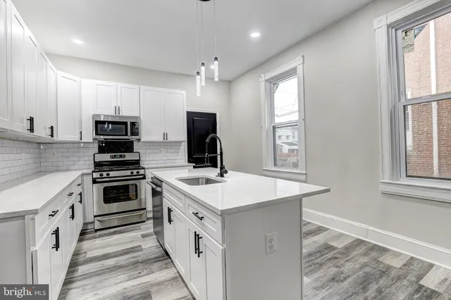 a kitchen with a stove a sink and a window