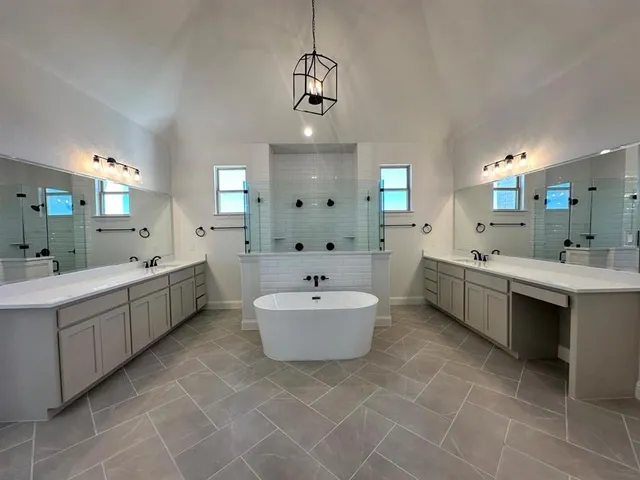 a bathroom with a double vanity sink mirror and bathtub