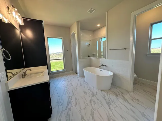a bathroom with a sink and mirror with toilet