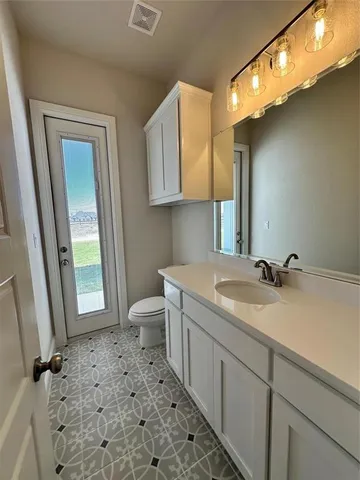 a bathroom with a sink a toilet and mirror