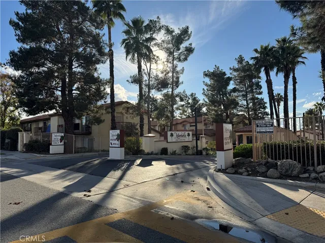 a row of palm trees in front of house