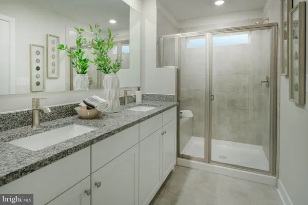 a bathroom with a granite countertop sink a mirror and a shower