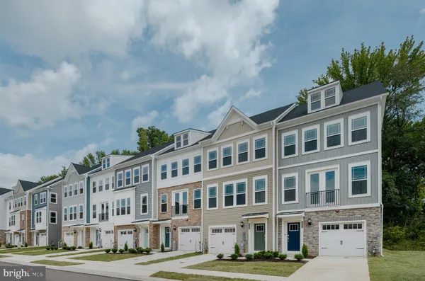 a front view of a building with lot of cars and trees