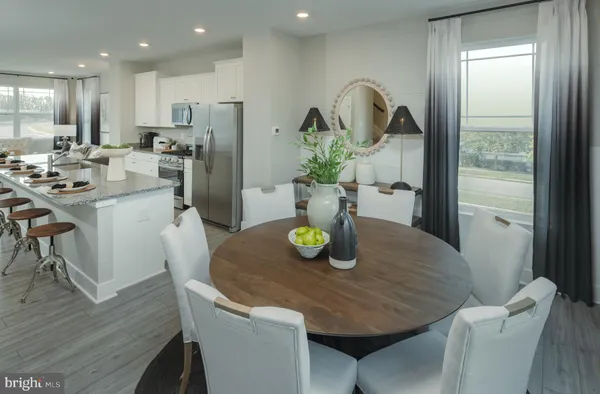 a kitchen with refrigerator and wooden floor