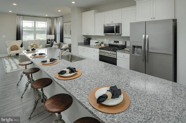 a kitchen with stainless steel appliances granite countertop a sink and a refrigerator
