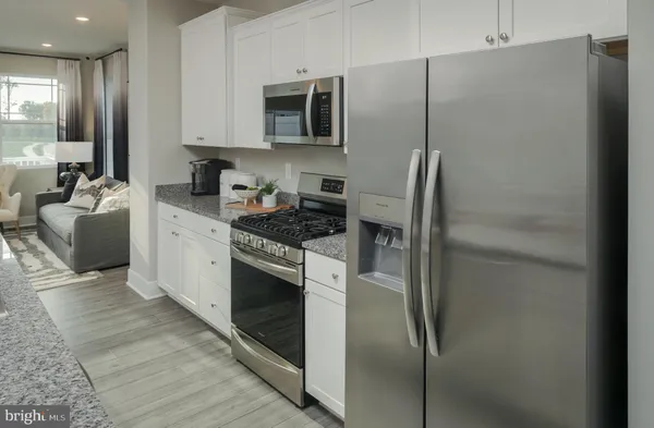 a kitchen with stainless steel appliances granite countertop a refrigerator a stove and a sink