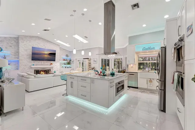 a kitchen with stainless steel appliances kitchen island granite countertop a table and chairs in it