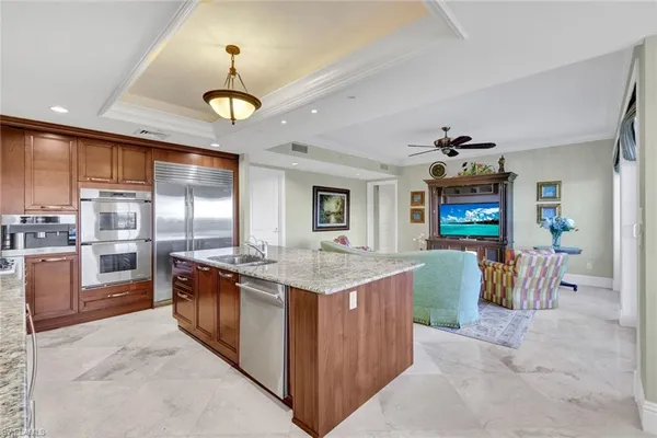 a large kitchen with kitchen island granite countertop a large counter top a sink stainless steel appliances and cabinets