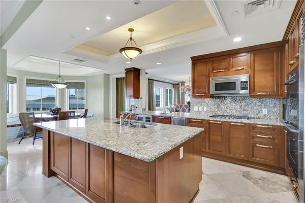 a kitchen with stainless steel appliances granite countertop a stove a sink and a microwave