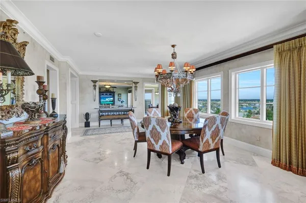 a dining room with furniture a chandelier and window
