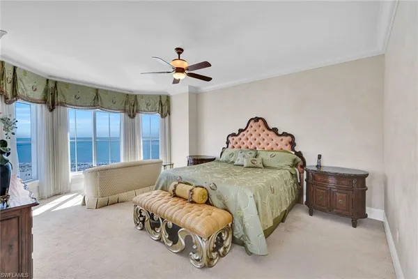 a bedroom with a large bed and a chandelier
