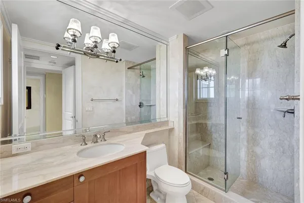 a bathroom with a bathtub shower sink mirror vanity and toilet