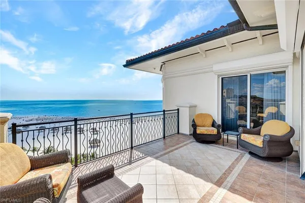 a view of a balcony with furniture and a floor to ceiling window