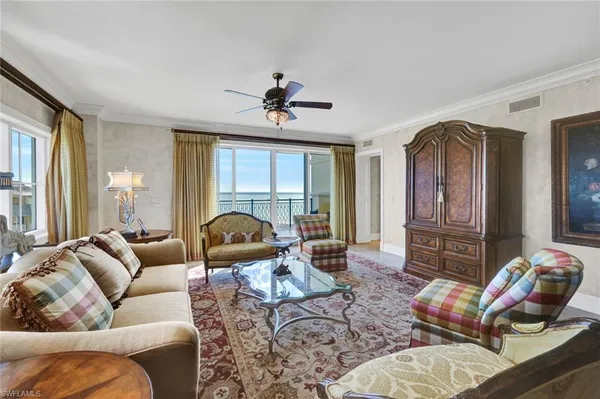 a living room with furniture a floor to ceiling window and a flat screen tv