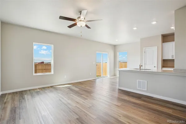 a view of an empty room with window and wooden floor