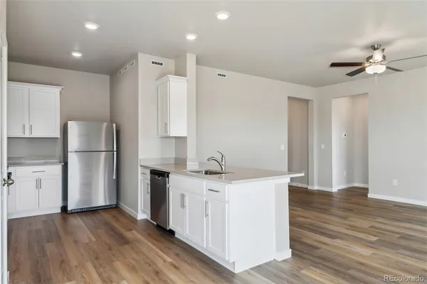 a kitchen with a refrigerator a sink and dishwasher a oven with wooden floors