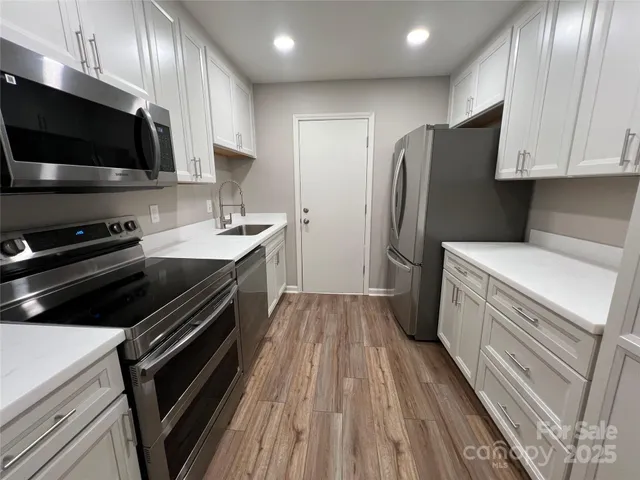a kitchen with a sink stainless steel appliances and cabinets