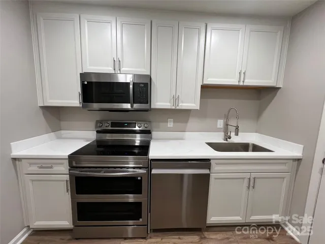a kitchen with white cabinets and stainless steel appliances